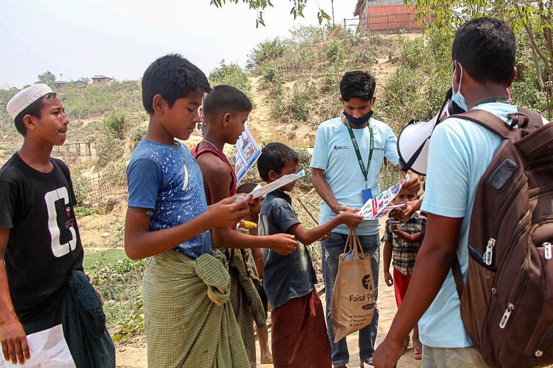 CPI-supported WASH volunteers distribute water safety information in Kutupalong Refugee Camp, Cox's Bazar, Bangladesh.