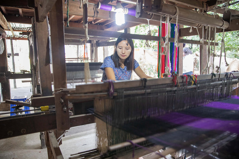 A weaver works at her loom. 