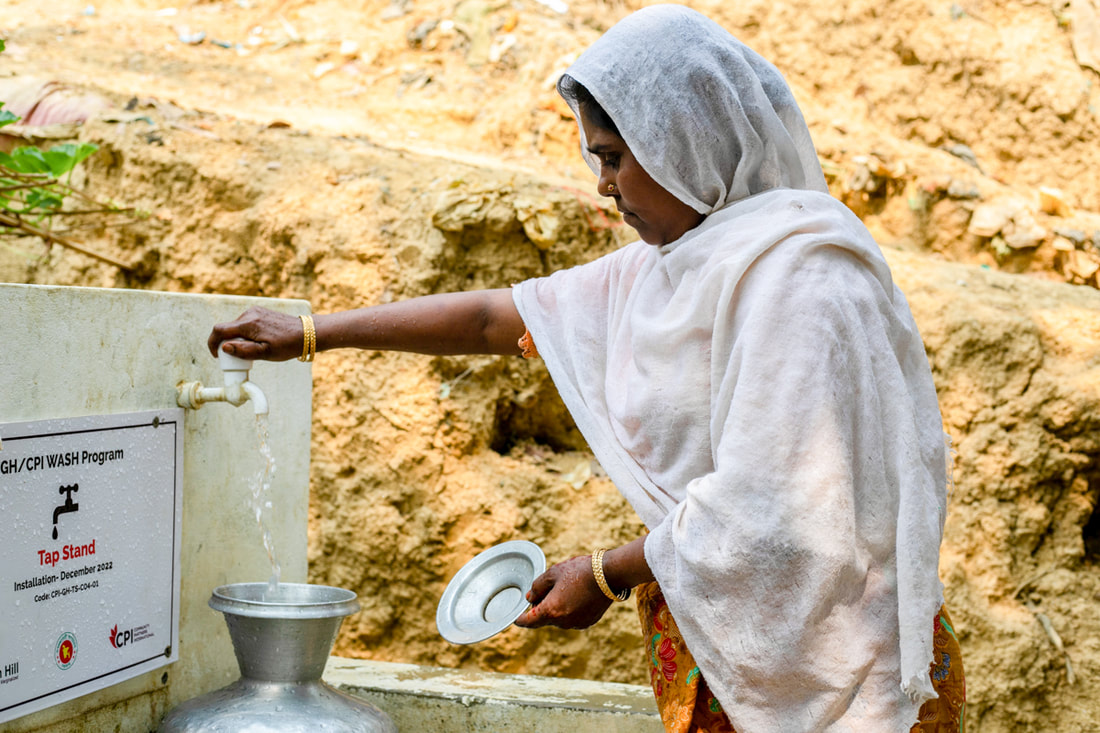 Hasina fills a water pot at the new tap stand near her shelter connected to the water network in Camp 4, Kutupalong Refugee Camp, Cox's Bazar, Bangladesh.