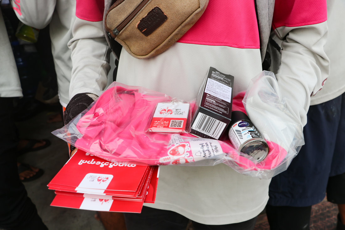 A Foodpanda rider receives TB awareness materials at an awareness session in Yangon, Myanmar, in March 2023.