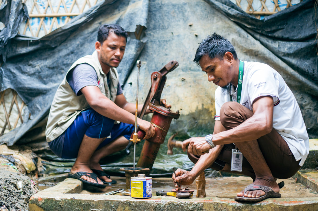 Water, sanitation and hygiene worker Abdu (right) and a colleague repair a water well in Kutupalong Refugee Camp, Bangladesh.