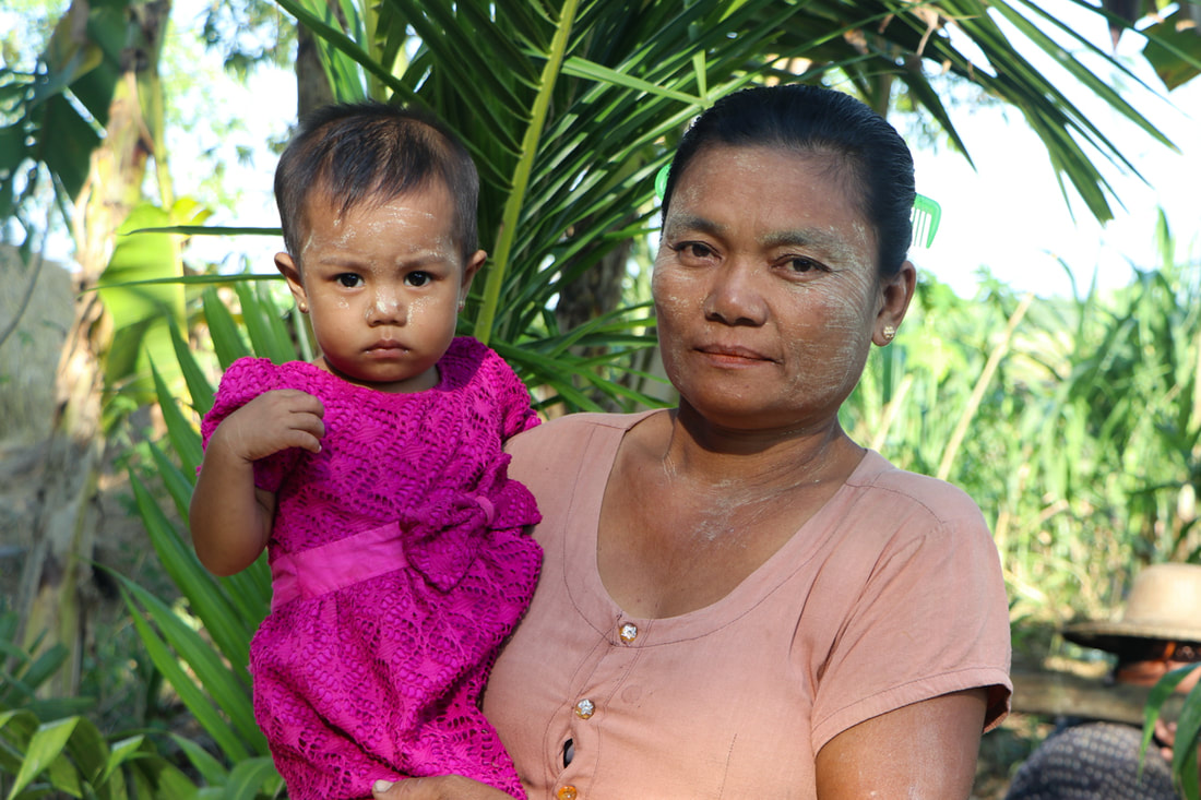Than Than Win, leader of the Shwe Bo Su women's union, at home with her granddaughter.