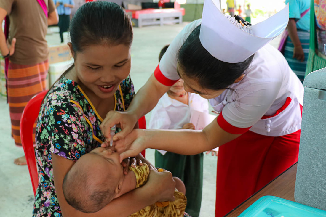 An auxiliary midwife vaccinates a baby during an immunization campaign in Kayin State, Myanmar.