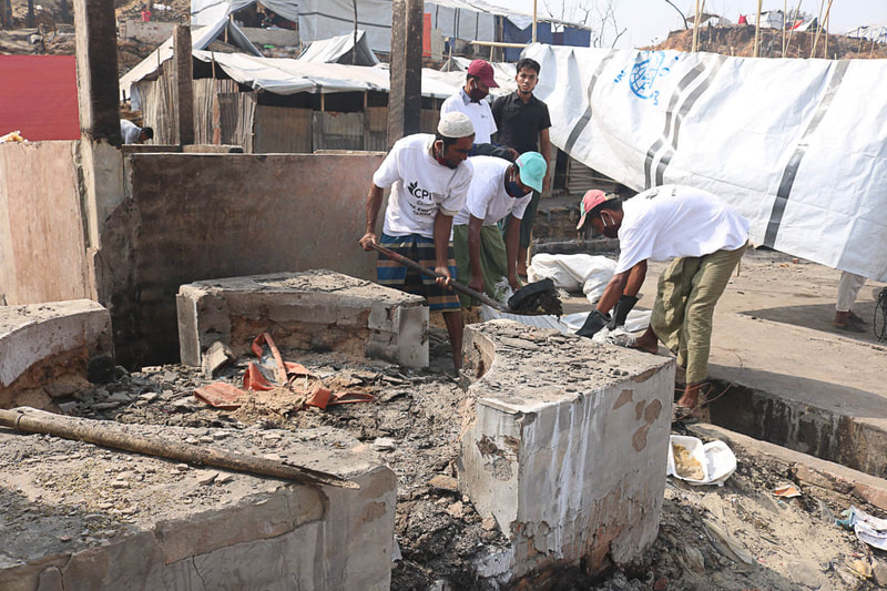 Host community and Rohingya volunteers clear fire debris in Kutupalong Refugee Camp.

