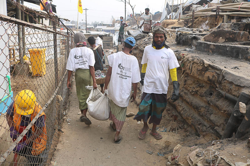 
Host community and Rohingya volunteers clear fire debris in Kutupalong Refugee Camp.