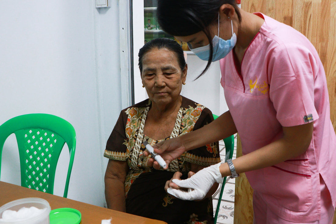 A patient undergoes diabetes monitoring at Nae Thit Kyan Mar's clinic in Dagon Seikkan Township, Yangon, Myanmar.