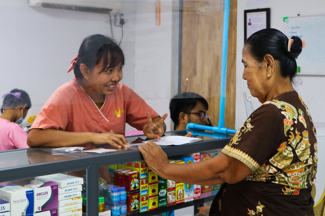 A patient talks to a pharmacist at Nae Thit Kyan Mar's clinic in Dagon Seikkan Township, Yangon, Myanmar.