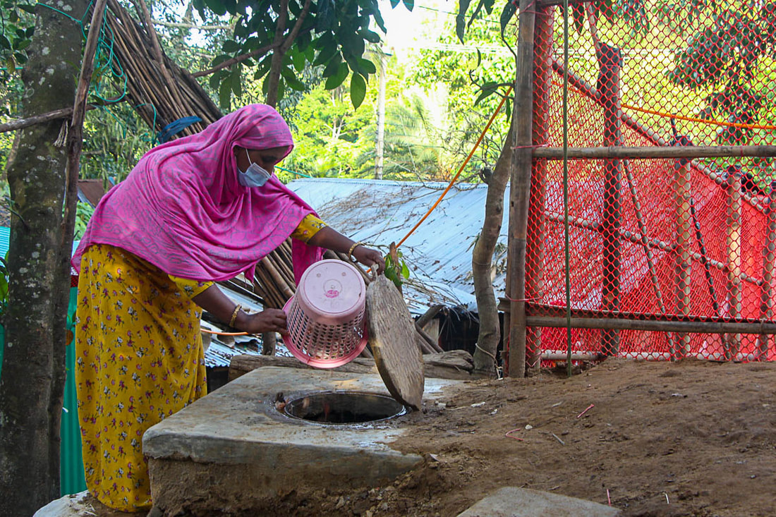 A Doria Nagar community member tips organic kitchen waste into the biogas plant chamber.