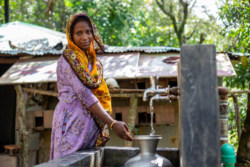 A woman fills a water container at a tapstand that forms part of the CPI-supported water network in Doria Nagar village, Cox's Bazar, Bangladesh.