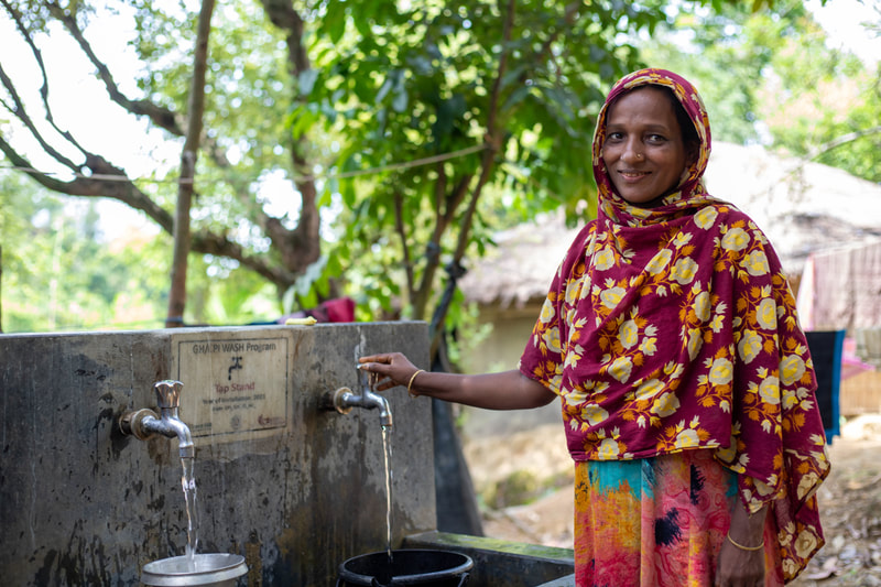 A woman fills a water container at a tapstand that forms part of the CPI-supported water network in Doria Nagar village, Cox's Bazar, Bangladesh.