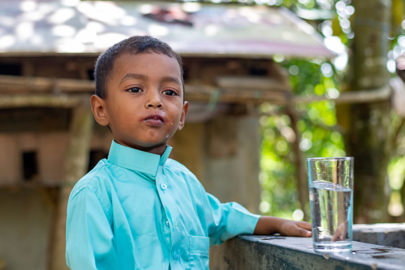 A boy drinks water from a tapstand that forms part of the CPI-supported water network in Doria Nagar village, Cox's Bazar, Bangladesh.
