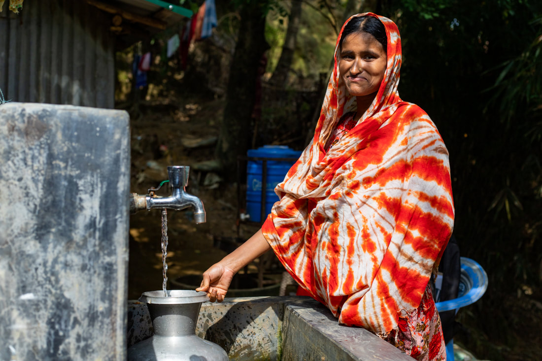 Morsheda fills a water container at a tapstand that forms part of the CPI-supported water network in Doria Nagar village, Cox's Bazar, Bangladesh.