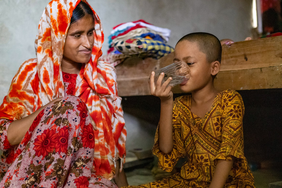 Morsheda watches her daughter drink water from the CPI-supported water network in Doria Nagar village, Cox's Bazar, Bangladesh.