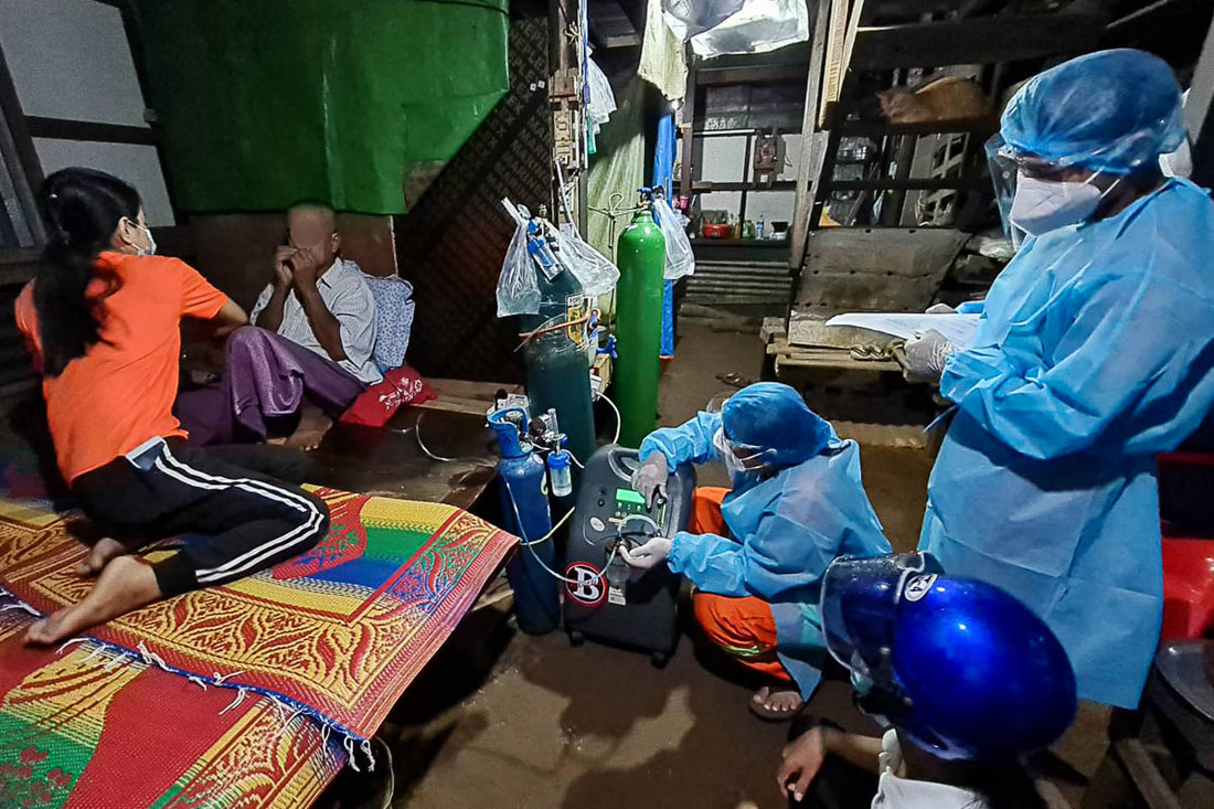 Representatives from the Bo Bo Win Rescue Foundation visit a COVID-19 patient at home to install an oxygen concentrator provided by Community Partners International.