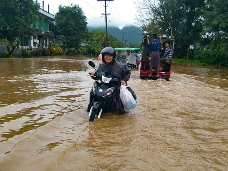 A motorcyclist pushes their motorcycle through floodwaters in Karen (Kayin) State, Myanmar. 